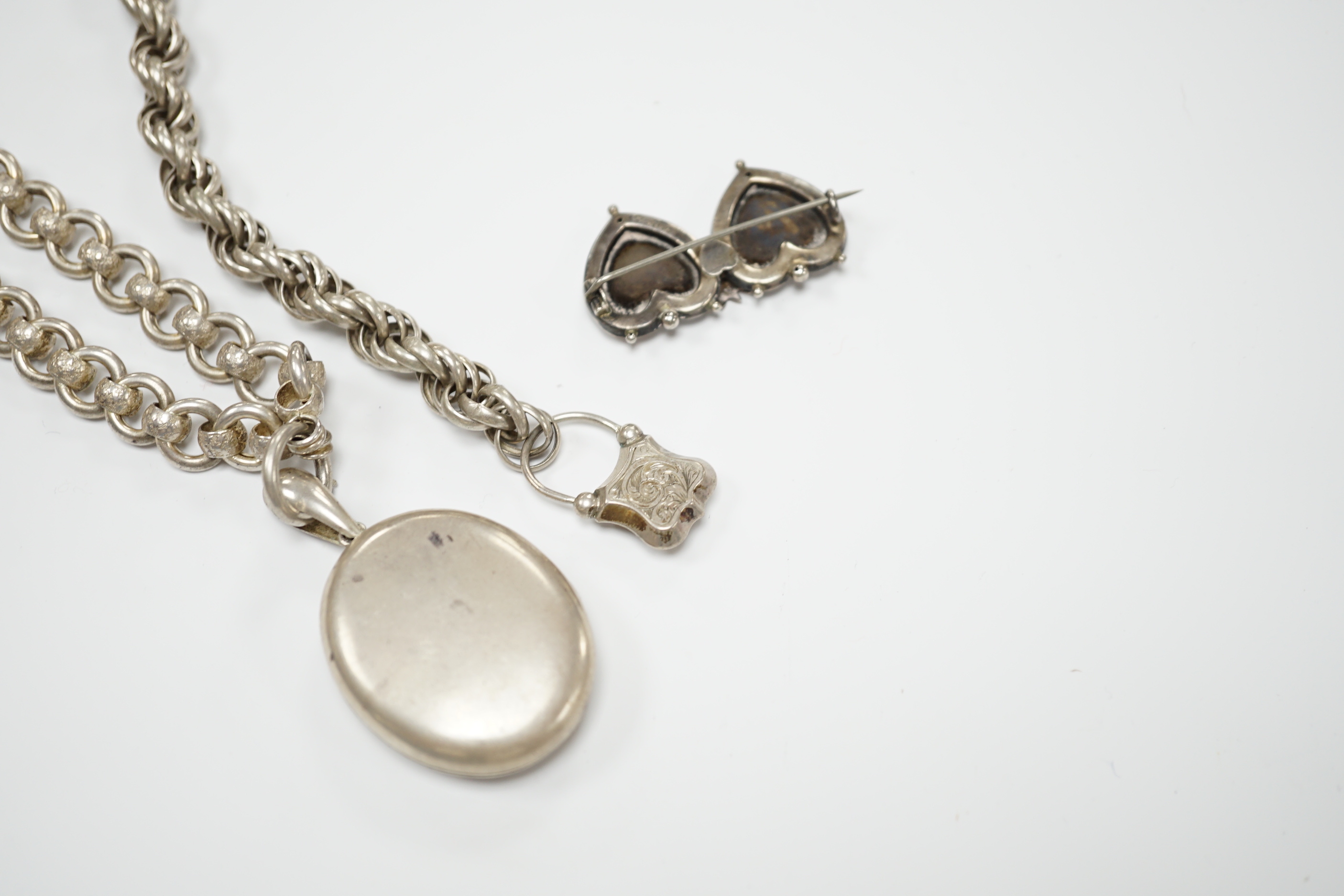 A Victorian white metal chains with a locket, a white metal bracelet and a sterling double heart shaped brooch.